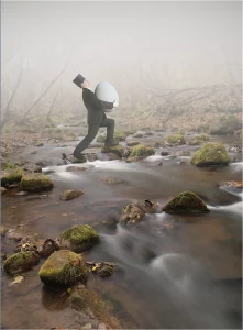 Peinture d'un homme qui transporte un œuf et marche sur une rivière 